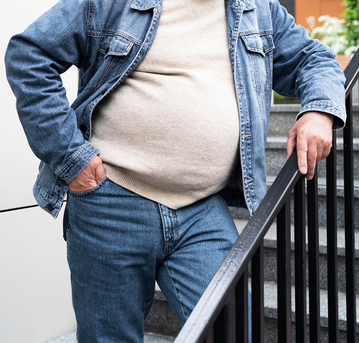 Un homme avec du ventre qui porte un pull et un jean