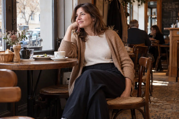 Femme assise au café dans une tenue confortable après un repas