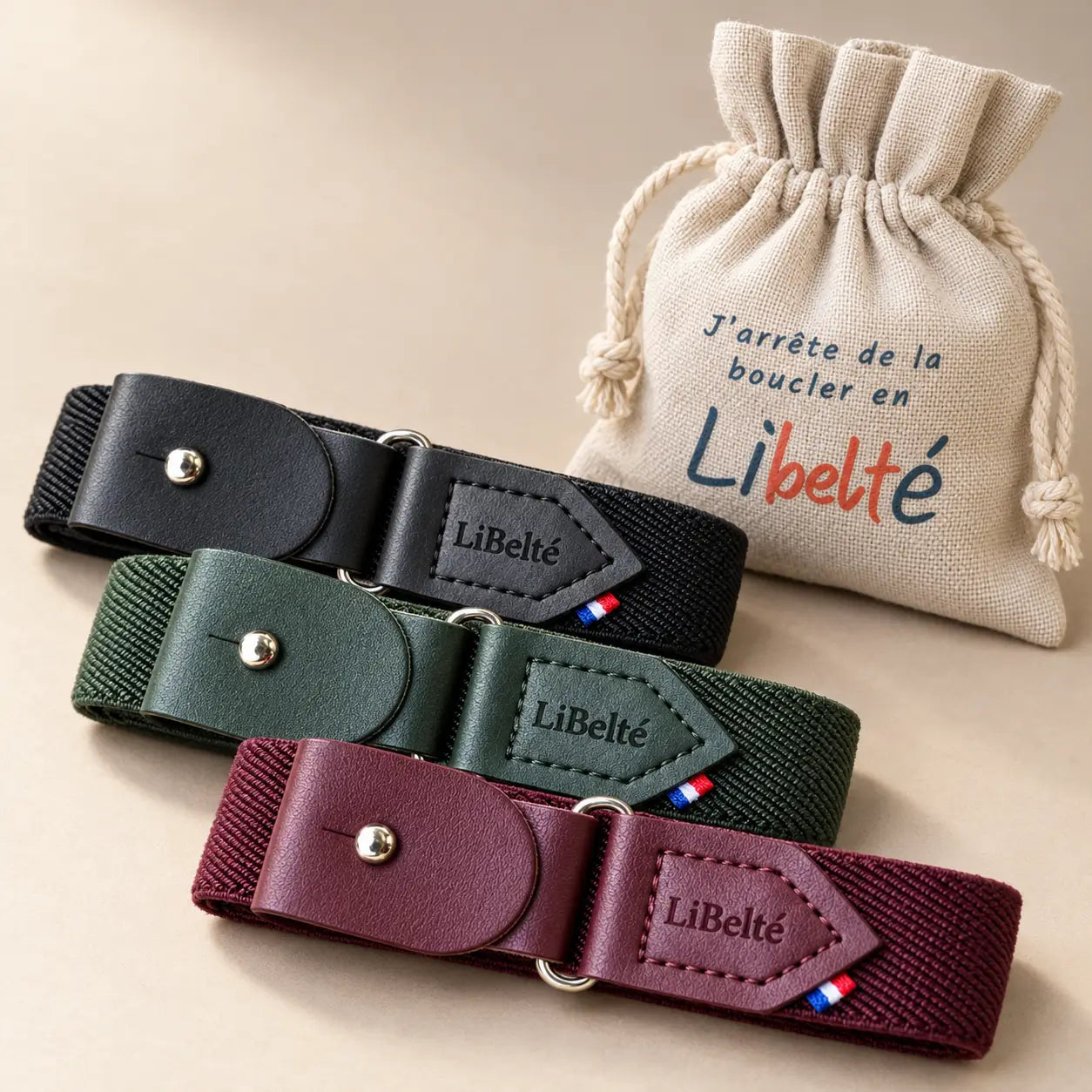 Trois ceintures enfant Libelté noire, olive et bordeaux, présentées avec leur pochon en lin.